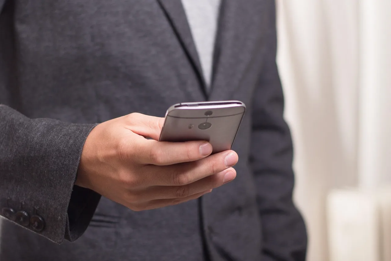 Smartphone showing an outgoing call screen, held in one hand